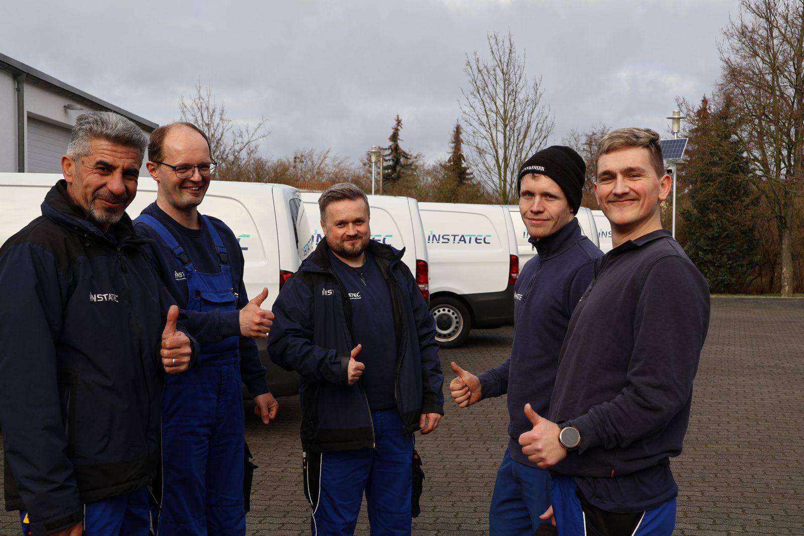 INSTATEC-Team vor der eigenen Servicefahrzeug-Flotte